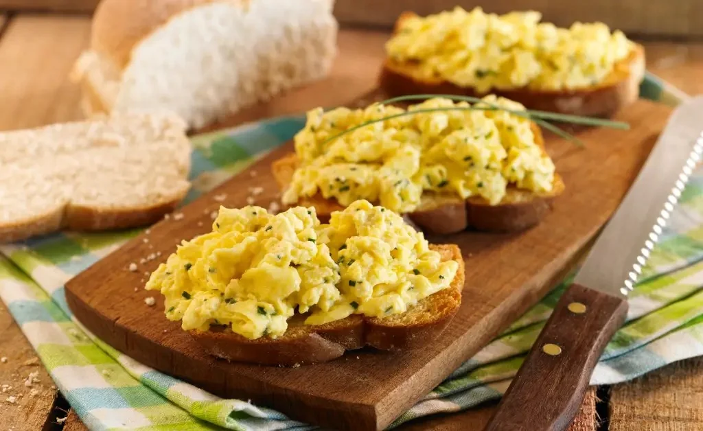 Huevos revueltos sobre bruschettas